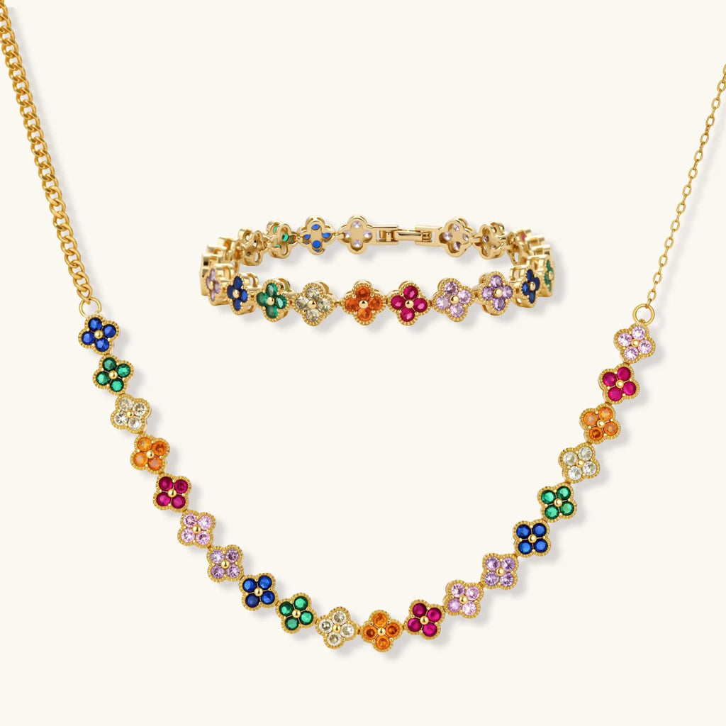 Colorful four-leaf clover jewelry set with rainbow cubic zirconia stones in gold-plated setting on white background