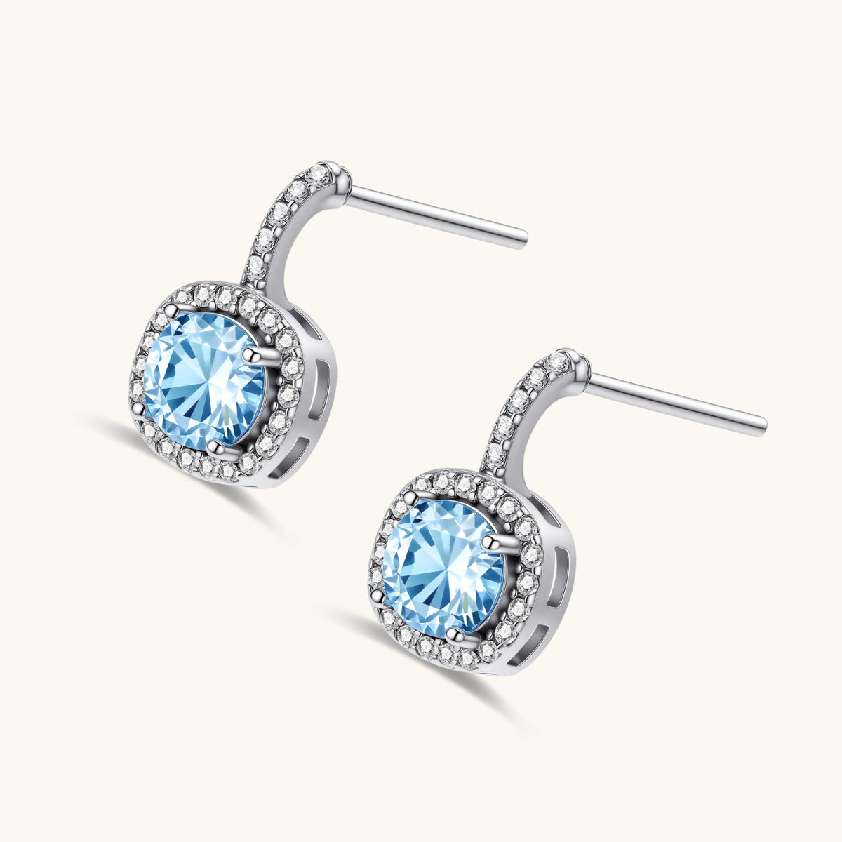 Sterling silver drop earrings featuring cushion-cut blue moissanite stones surrounded by sparkling halo settings