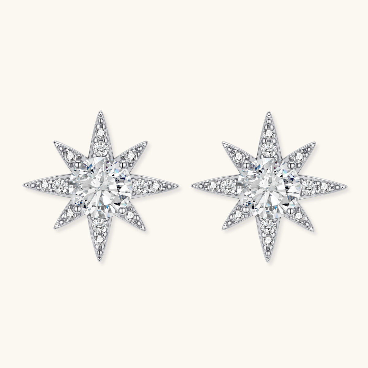 Sterling silver star-shaped stud earrings with brilliant moissanite center stones and pavé details on neutral background.