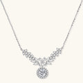 Elegant sterling silver necklace featuring intricate wing-like design with brilliant moissanite stones on neutral background.