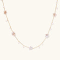 Gold vermeil chain with iridescent star-shaped baroque pearls and small round freshwater pearl drops on cream background.