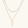Three-layered gold necklace set with graduated cross pendants in mixed chain styles on white background.