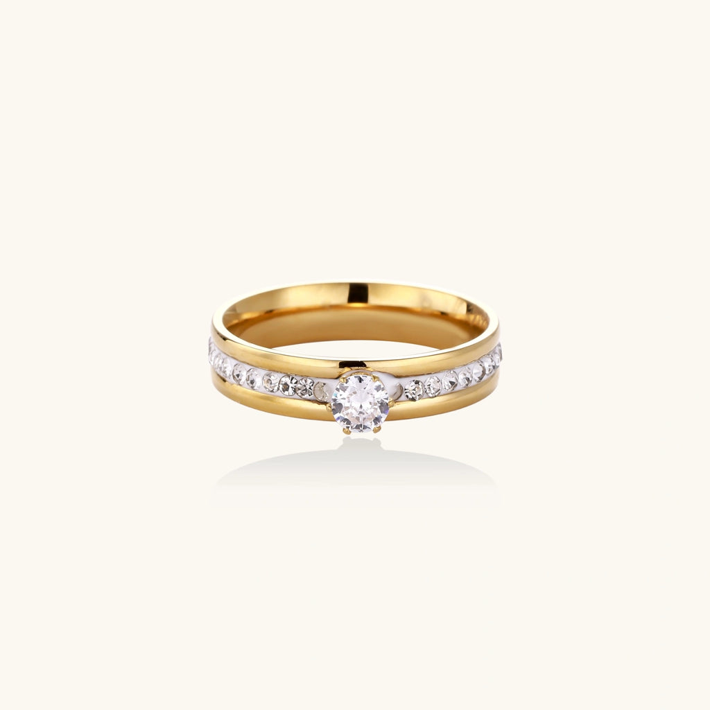 Gold-plated double-band ring with center rhinestone solitaire and channel-set stones on white background