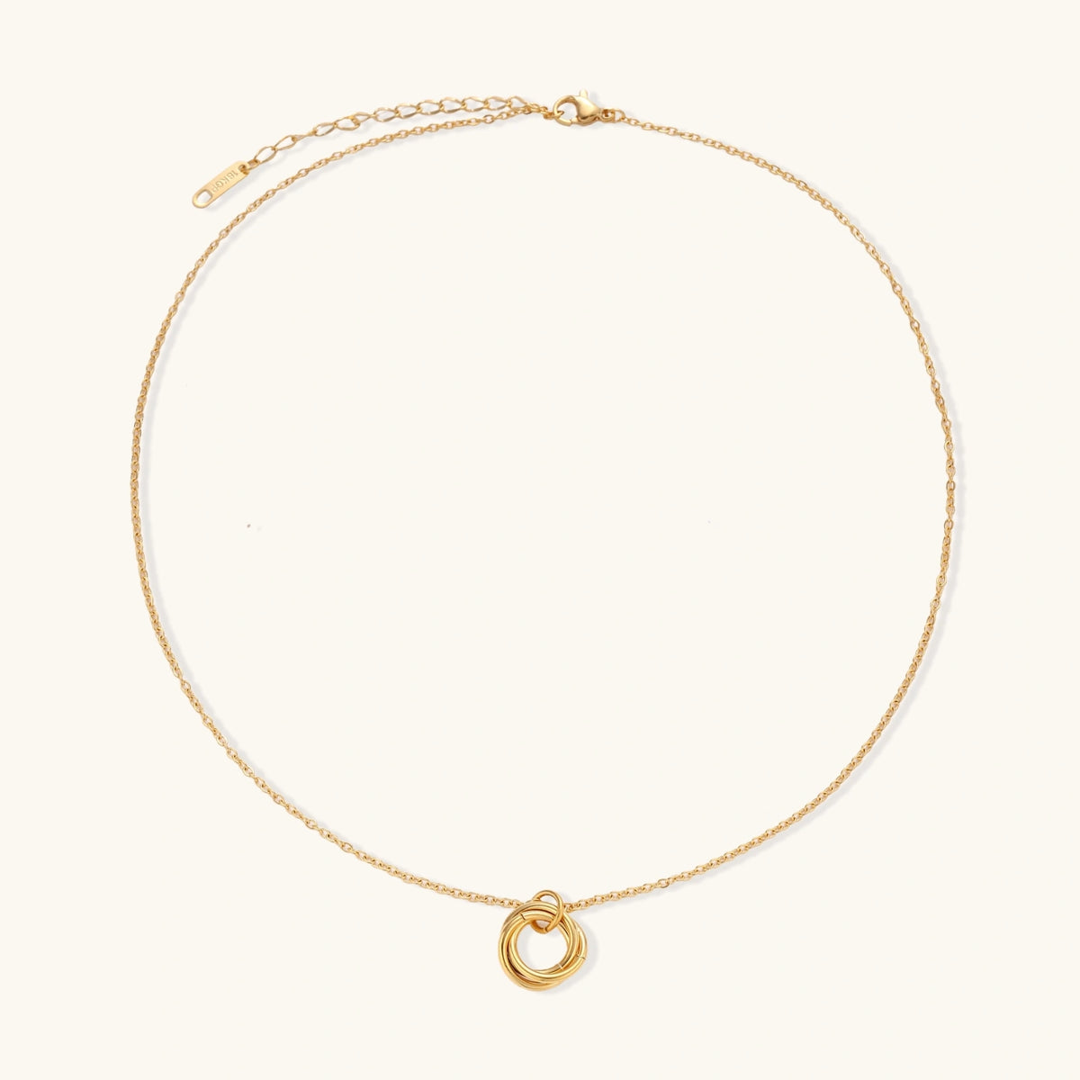 Delicate gold-plated necklace with three interlocking circle rings forming a minimalist knot pendant on cream background