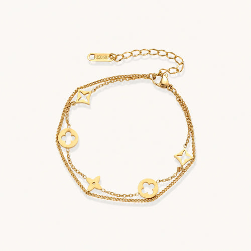 Double-layer gold-plated bracelet with quatrefoil and star charms on cream background, 18K gold finish.